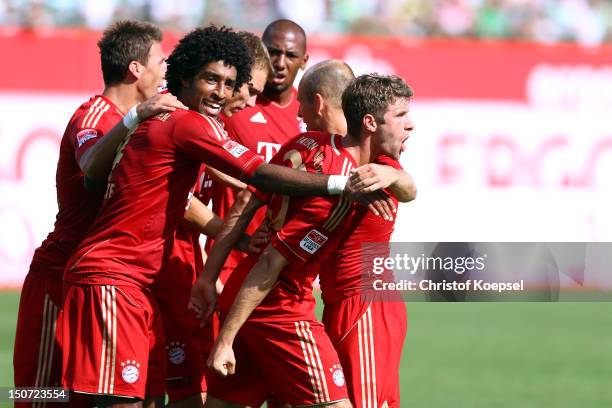Thomas Mueller of Bayern celebrates the first goal with Mario Mandzukic and Dante of Bayern during the Bundesliga match between Greuther Fuerth and...