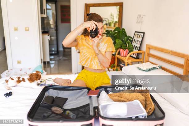 young woman packing her suitcase for vacation - possession stock pictures, royalty-free photos & images