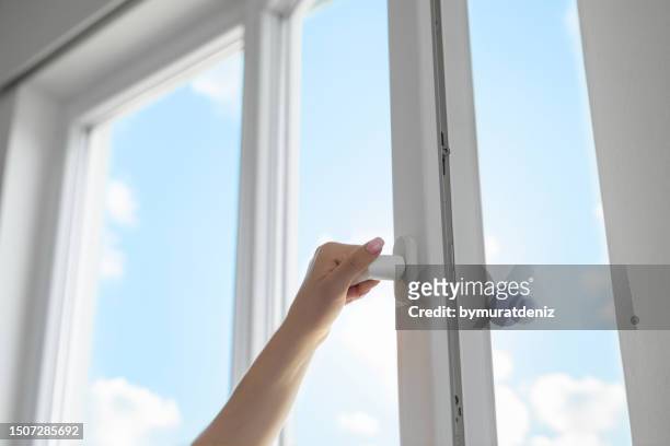 woman opening window - windowframe stockfoto's en -beelden