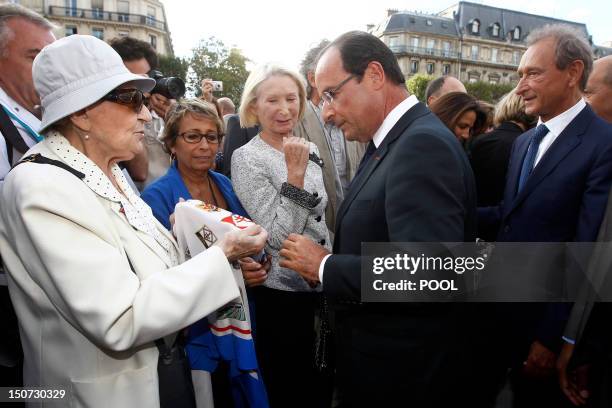 French President Francois Hollande and Paris Mayor Bertrand Delanoe listen to an elderly woman as they attend a ceremony marking the 68th anniversary...