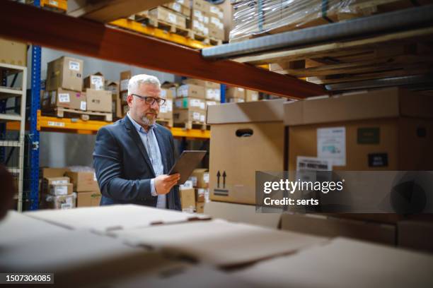 factory manager using a digital tablet in a warehouse - human body part stock pictures, royalty-free photos & images