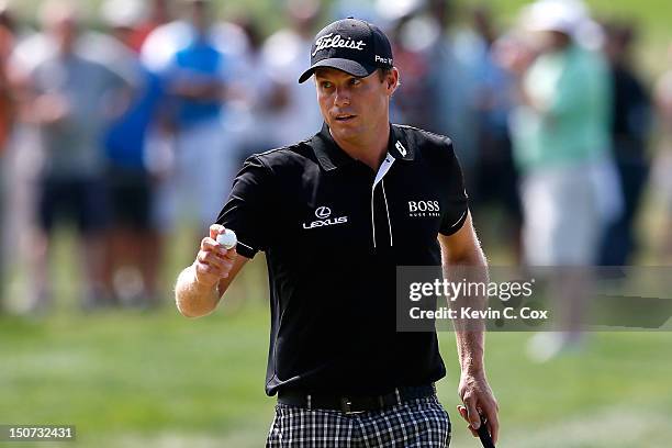 Nick Watney waves his ball towards the fans as he reacts after he made a birdie putt on the first hole during the third round of The Barclays at the...