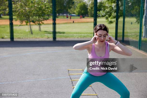 a woman working out in her local park using an agility ladder - human muscle stock pictures, royalty-free photos & images