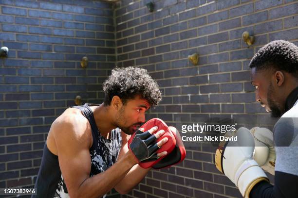 a man boxing training with his fitness instructor in an outdoor gym in the city - human muscle stock pictures, royalty-free photos & images