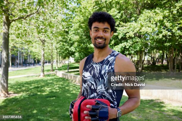 portrait of a smiling fitness instructor outside in a city park - human muscle stock pictures, royalty-free photos & images