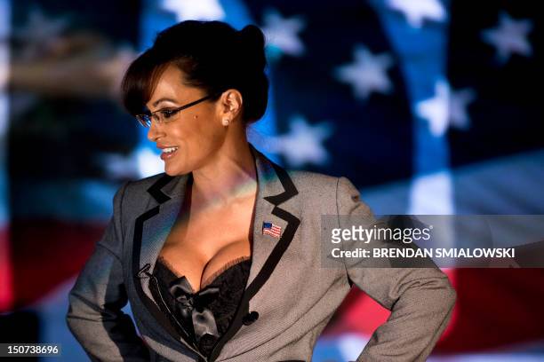 Lisa Ann, an adult film star and Sarah Palin tribute artist, gets up after speaking to members of the press at Thee DollHouse gentleman's club on...