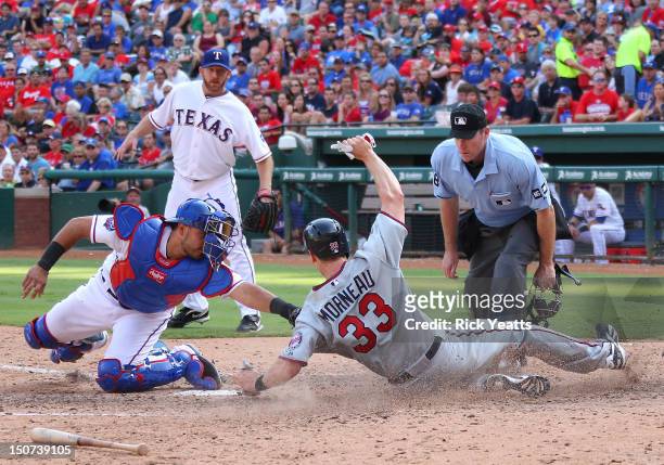 Ryan Dempster of the Texas Rangers and home plate umpire Chris Conroy looks on as Geovany Soto tags Justin Morneau of the Minnesota Twins at Rangers...