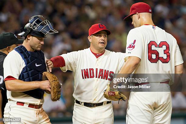 Pitching coach pitching coach Ruben Niebla talks with catcher Lou Marson and starting pitcher Justin Masterson of the Cleveland Indians during the...