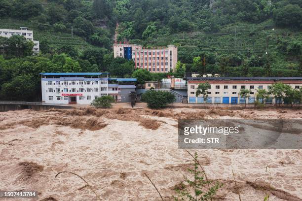 This photo taken on July 4, 2023 shows the water of an overflowing river flooding an area at the Wanzhou district in China's southwestern Chongqing....