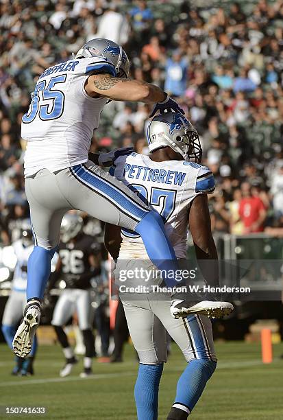 Brandon Pettigrew and Tony Scheffler of the Detroit Lions celebrate after Pettigrew caught a seven yard touchdown pass against the Oakland Raiders in...