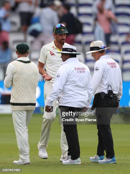 Mitchell Starc of Australia speaks to Umpire Chris Gaffaney and Umpire Ahsan Raza at stumps after he was rules to have dropped his catch to dismiss...