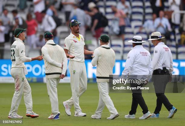 Mitchell Starc of Australia speaks to Umpire Chris Gaffaney and Umpire Ahsan Raza at stumps after he was rules to have dropped his catch to dismiss...