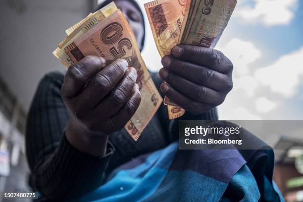 Street vendor counts out Zimbabwean 50 dollar banknotes in the central business district of Harare, Zimbabwe, on Wednesday, July 5, 2023. Consumer...