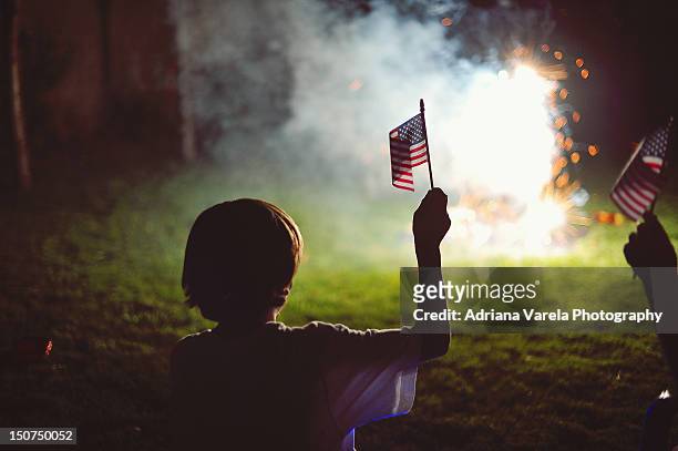 boy with flag - american flag fireworks stockfoto's en -beelden