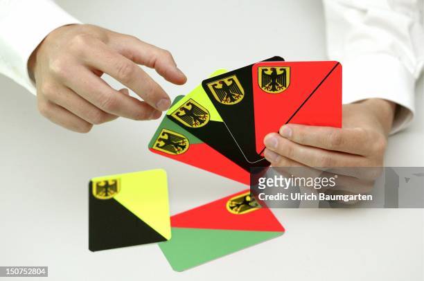 Symbolic picture to the topics: possible coalitions, parties, parliamentary election, Our picture shows a hand holding play card in the colours...