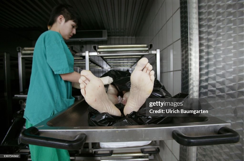 Institute for forensic medicine of the Univerity of Bonn: Employee of the institute with the dead body of a man in the cold room.