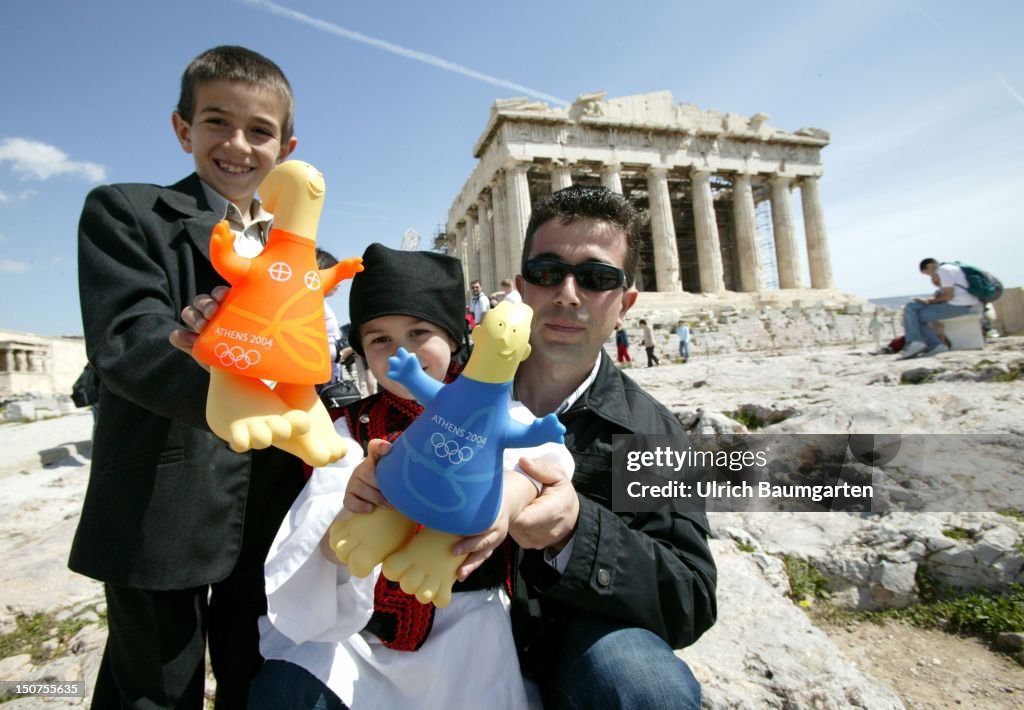Family on the acropolis with the official mascot ( Athena and Phevos ) of the 28th Olympic Games 2004 in Athens.