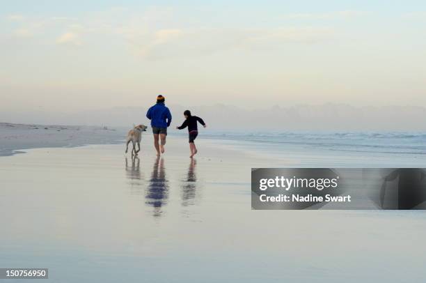 seasand sprint - boy running with dog stock-fotos und bilder