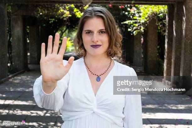 woman looking at the camera and gesturing to stop - hand geste halt stock-fotos und bilder