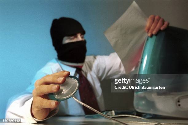 Symbolic picture: Man with mask at the computer .