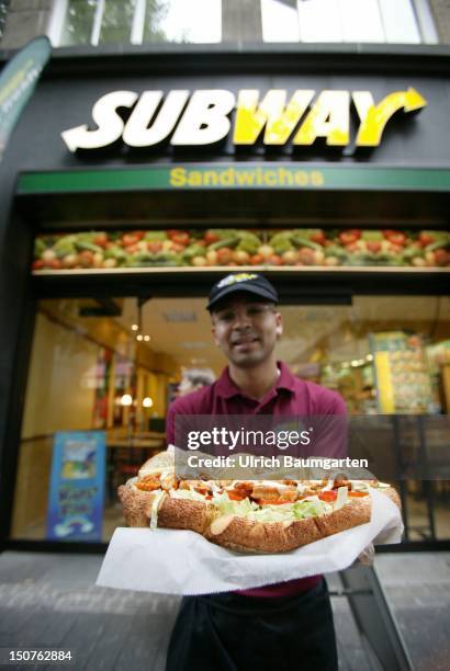 Employee of the US American sandwich fast-food chain Subway with a sandwich.