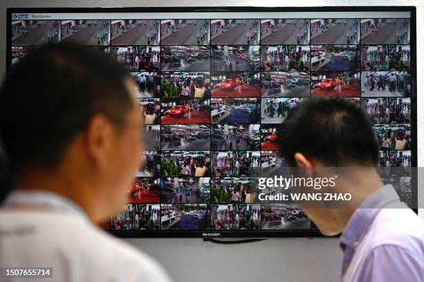 People are seen on screens from closed circuit television security cameras at the World Artificial Intelligence Conference in Shanghai on July 6,...