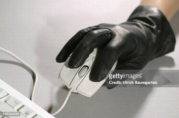 Symbolic picture: computer crime, Hand with a black clove is holding a computer mouse.