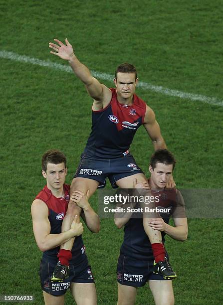 Brad Green of the Demons is chaired from the field after the round 22 AFL match between the Melbourne Demons and the Adelaide Crows at Melbourne...