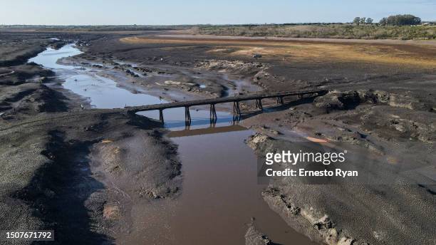 Aerial view of a bridge that emerged after 30 years under water of the Santa Lucia river at Paso Severino reservoir on July 01, 2023 in Florida,...