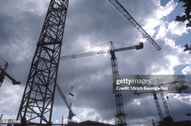 Cranes in front of a cloudy sky.