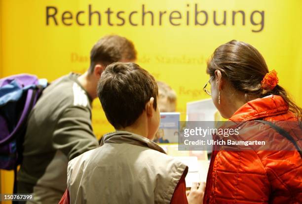 Children at a stable of the book fair in Frankfurt, In the back the writing - Rechtschreibung - on a outsized Duden of the German orthography.