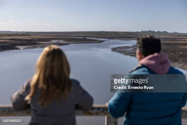 Couple looks the Santa Lucia river at Paso Severino reservoir on July 01, 2023 in Florida, Uruguay. 'La Niña' climatic phenomenon has brought Uruguay...
