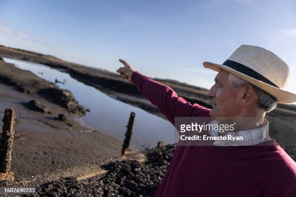 Person looks on from a bridge that emerged after 30 years of being under water of Santa Lucia river at Paso Severino reservoir on July 01, 2023 in...