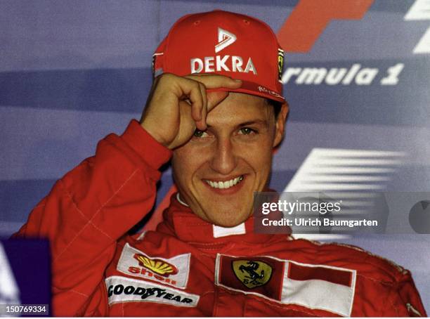 Satisfied,,, Michael SCHUMACHER, Formula-1 pilot of the Ferrari team, during a press conference, SCHUMACHER, laughing, puts on his hat.