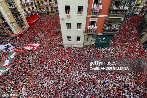 Participants wave their red scarves during the "Chupinazo" opening ceremony to mark the kick-off of the San Fermin bull Festival outside the Town...