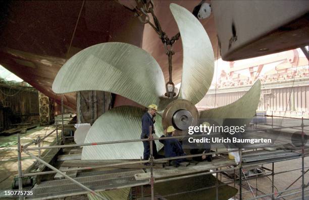 The mounting of a 41 tonns heavy ship's propeller onto the drive shaft of a container ship within the dry dock of the Howaldts-Werke Deutsche Werft...