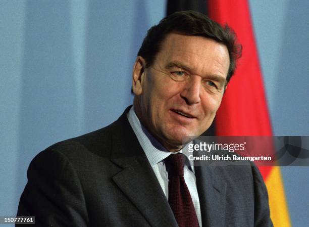 Gerhard SCHROEDER , Federal Chancellor, in front of the German flag.
