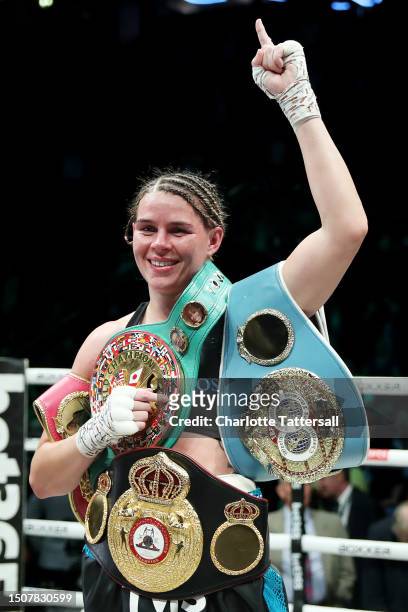 Savannah Marshall poses for a photograph wearing her title belts whilst celebrating victory after defeating Franchon Crews-Dezurn during the IBF,...