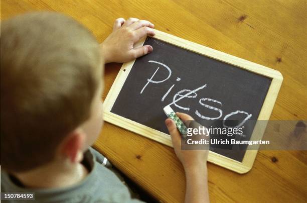 Symbolic photo to the topic: PISA - study, Our photo shows a child which has written " PIESA " and is now crossing out the " E ".