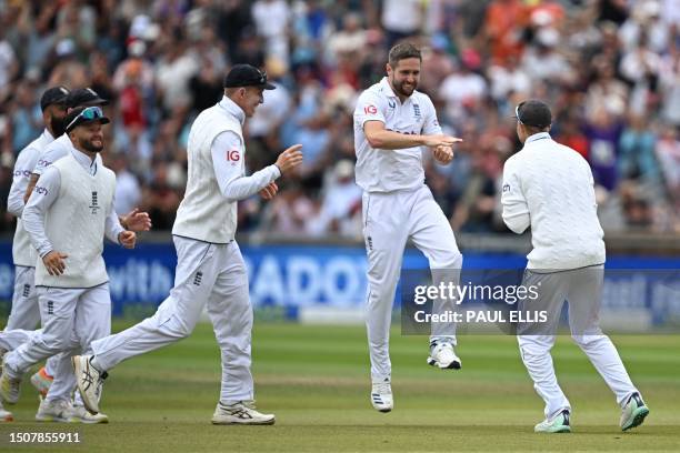 England's Chris Woakes celebrates as England's Joe Root takes a catch to dismiss Australia's Marnus Labuschagne off his bowling on day one of the...