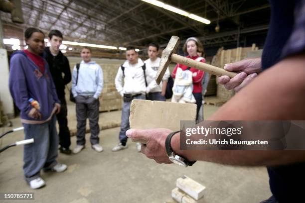 School class visiting bricklayer who's being trained at the - Bildungszentrum Butzweiler Hof der Handwerkskammer Koeln -.