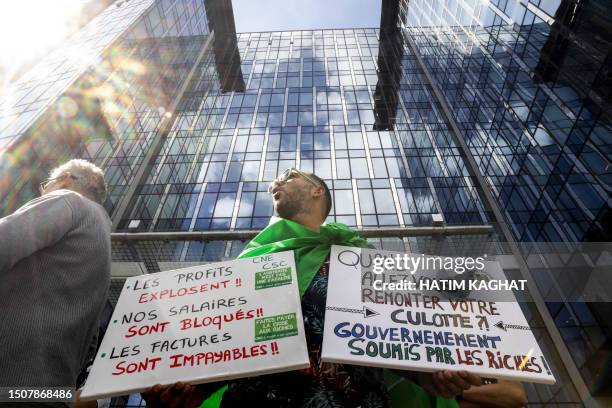 Protester stands with a plcard that reads "Profits explode. Our salaries are frozen. The bills are unpayable" during a "Code Red" protest action...