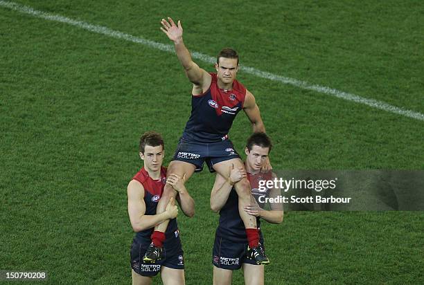 Brad Green of the Demons is chaired from the field after the round 22 AFL match between the Melbourne Demons and the Adelaide Crows at Melbourne...