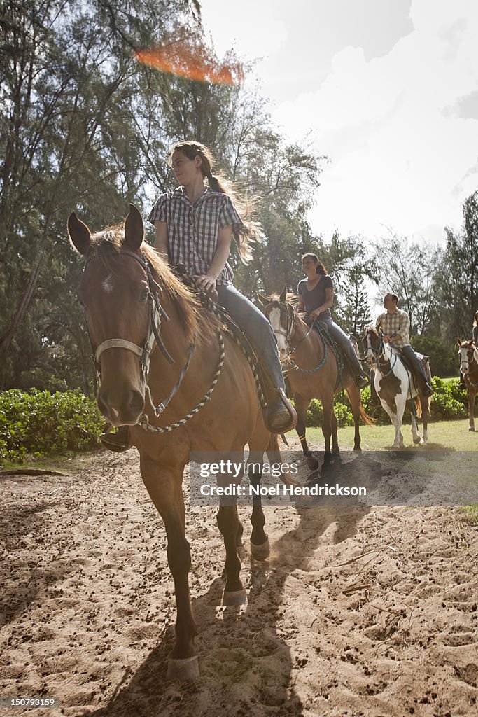 A group explores a trail on horseback