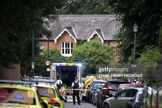 Police officer stands guard next to an ambulance behind a cordon following a car collision at the private Study Prep girls' school in Wimbledon,...