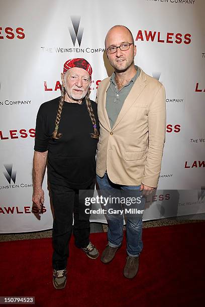 Musician Willie Nelson and author Matt Bondurant pose on the red carpet for the new film Lawless at the Alamo Drafthouse on August 25, 2012 in...