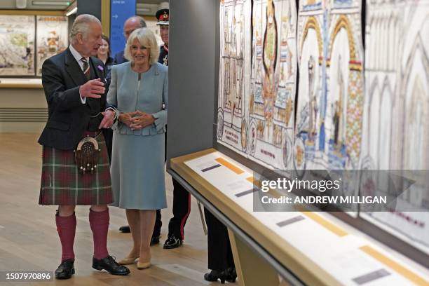 Britain's King Charles III and Britain's Queen Camilla study the tapestry during a visit to The great Tapestry of Scotland visitor centre in...