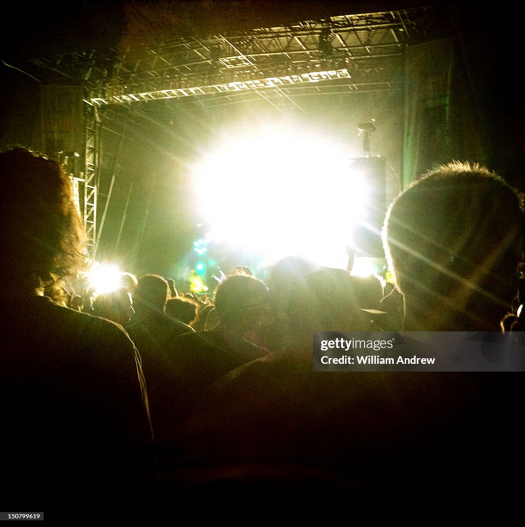 Concert crowd with glowing stage in background