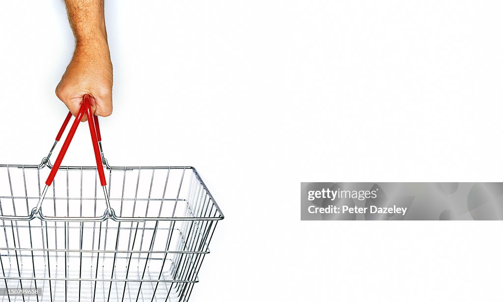A hand holding a supermarket basket