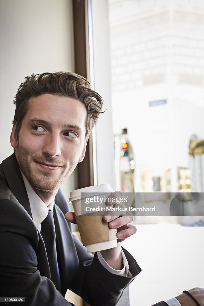 Confident man enjoying coffee to go.